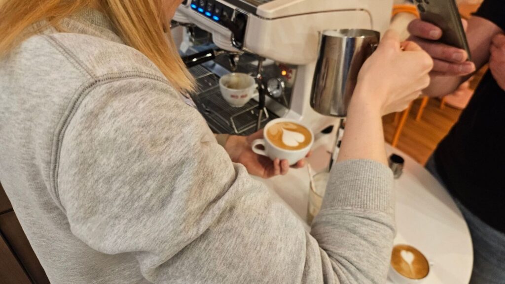 Szkolenie ze spieniania mleka i latte art przy ekspresie kolbowym w kawiarni