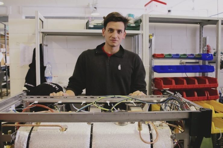 Technik przy ramie ekspresu kolbowego z bojlerem w izolacji i przewodami