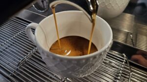 Espresso wypływające z kolby ekspresu kolbowego do filiżanki
